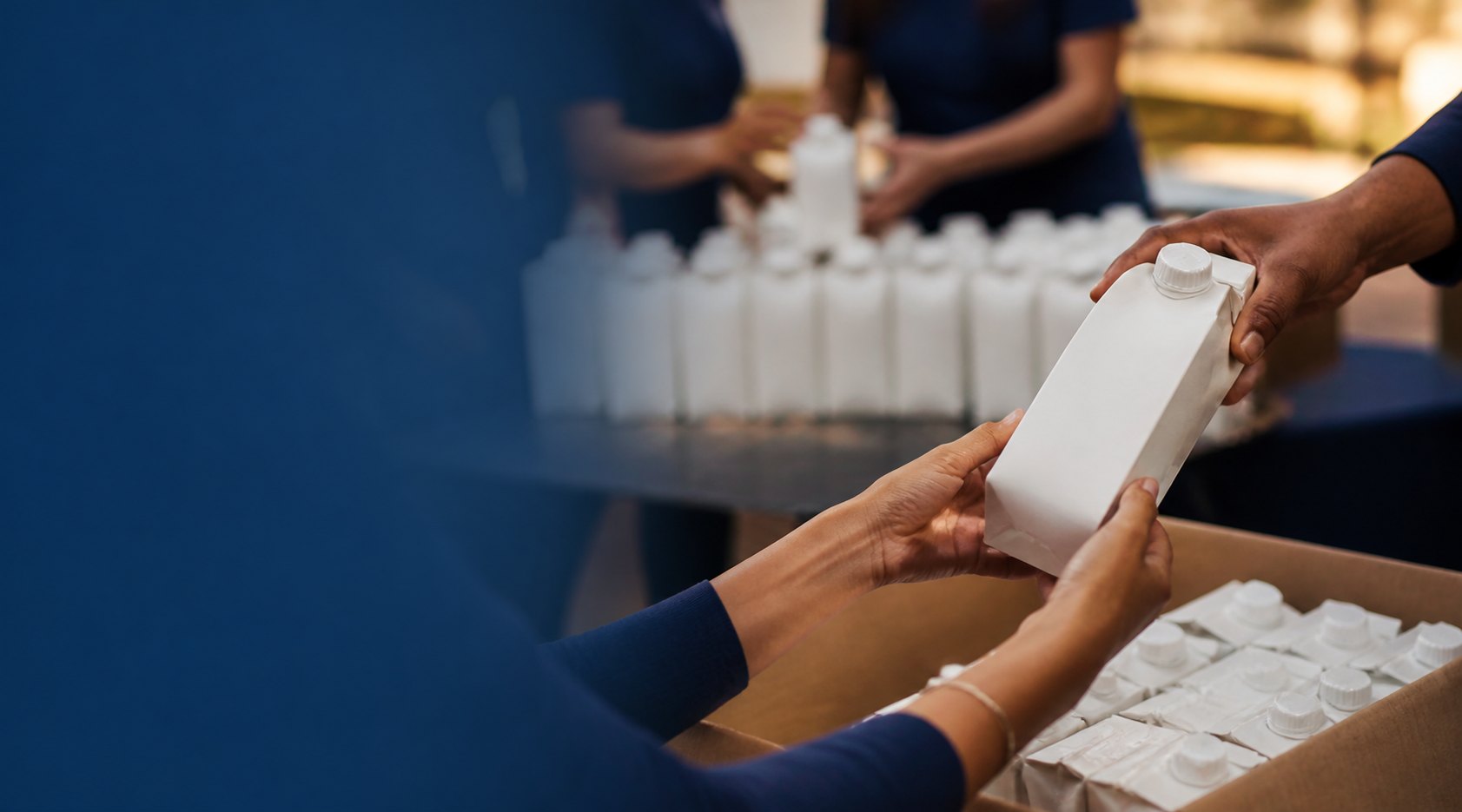 Voluntários organizando caixas de leite para doação